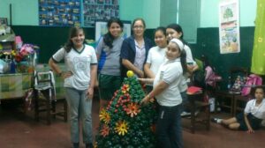 Las cinco alumnas con la docente Lic. Wilma Roa León y uno de los trabajos (árbol de navidad).