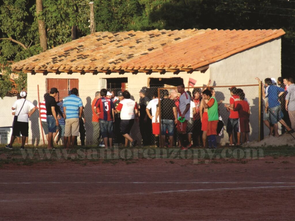 Dirigentes e hinchas reclamando al árbitro el gol anulado y la aparente terminación del juego antes del tiempo reglamentario